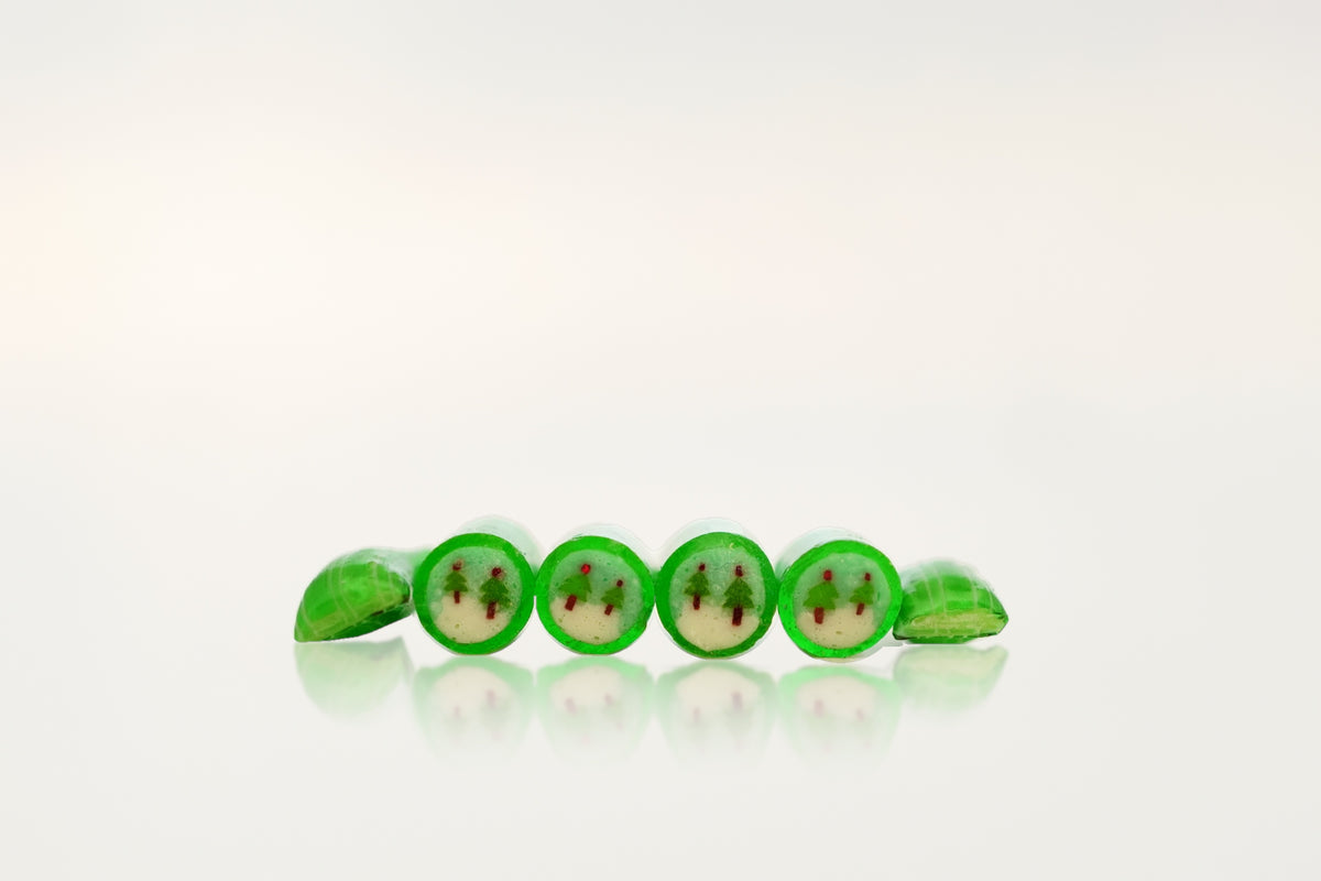 Winter forest green apple handmade rock candies in a row, showing the evergreen tree design – Candylabs